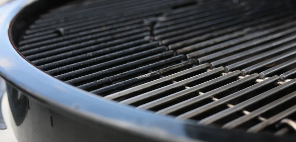 Nahaufnahme eines Grills mit einem zur H&auml;lfte gereinigten Grillrost