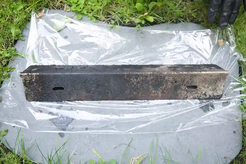 Brennerabdeckung (Flavorizer Bars) liegt im Gras auf einer Folie